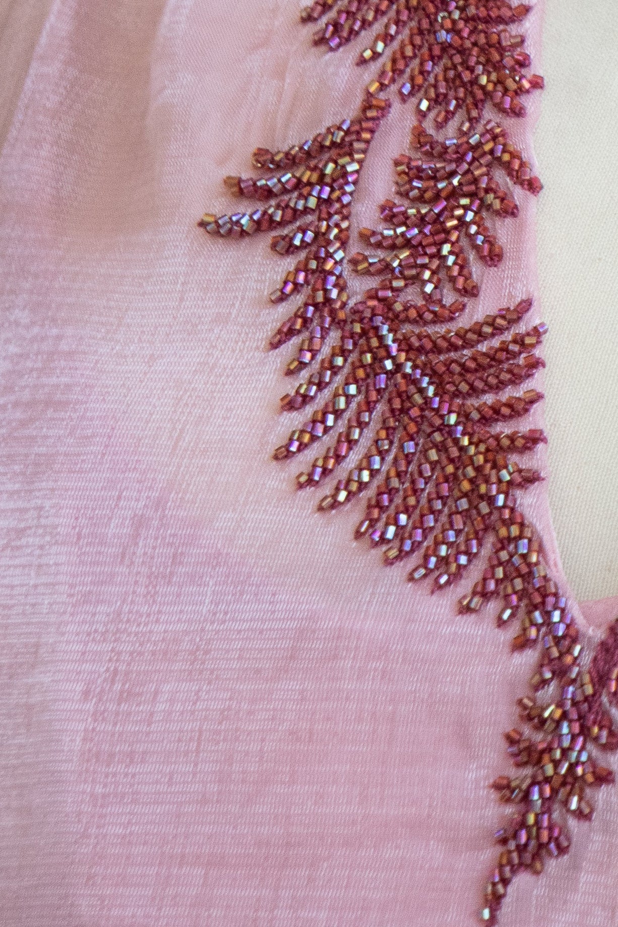 Close up of Modest luxury Melure dress crafted from sheer blush organza with delicate beaded neckline and feminine movement

