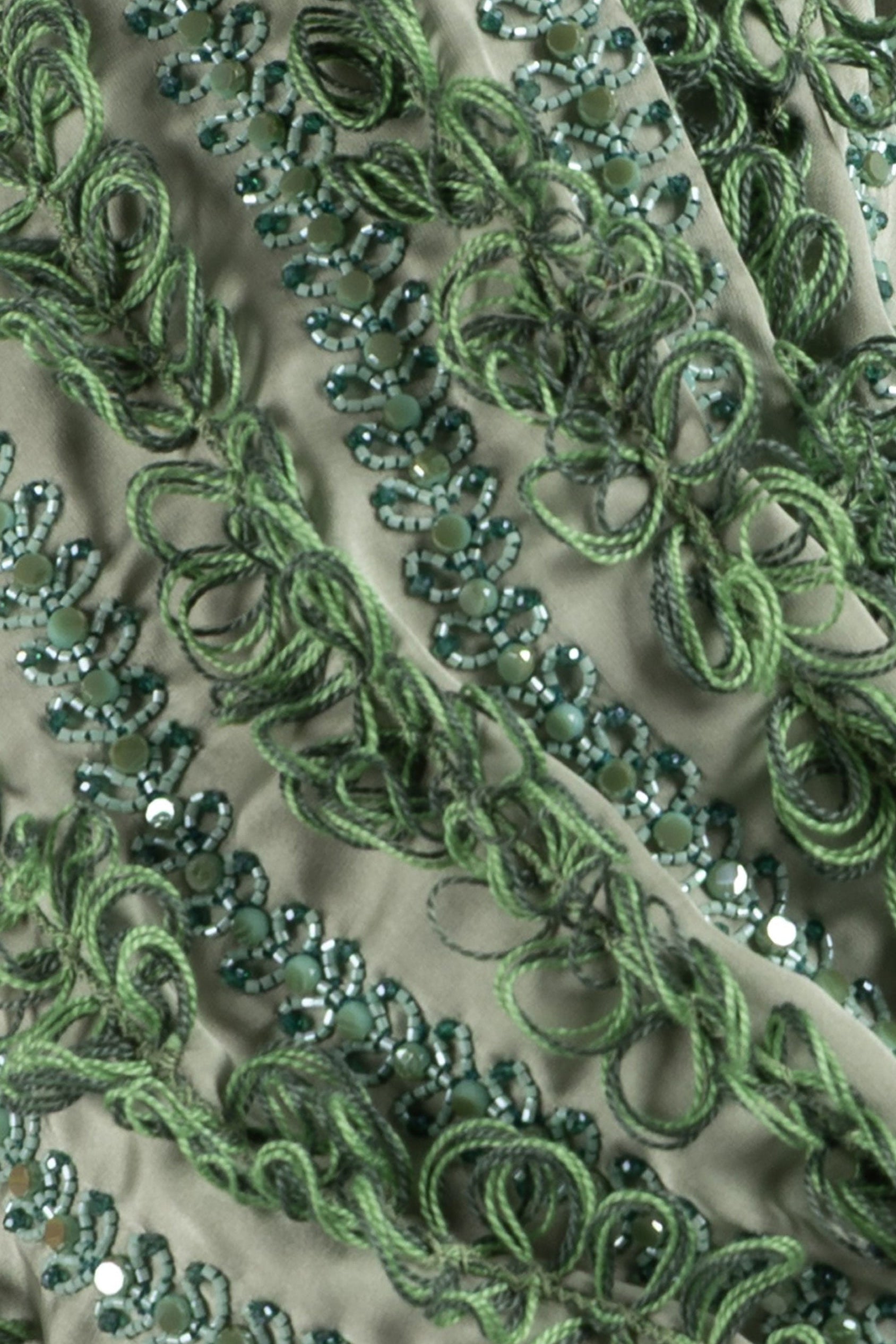 close up of satin maxi dress with sculptural sleeves and crystal details
