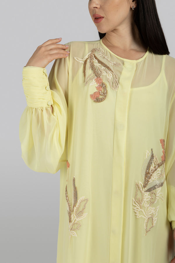 Butter-yellow chiffon dress with flowing silhouette and playful ruffles
