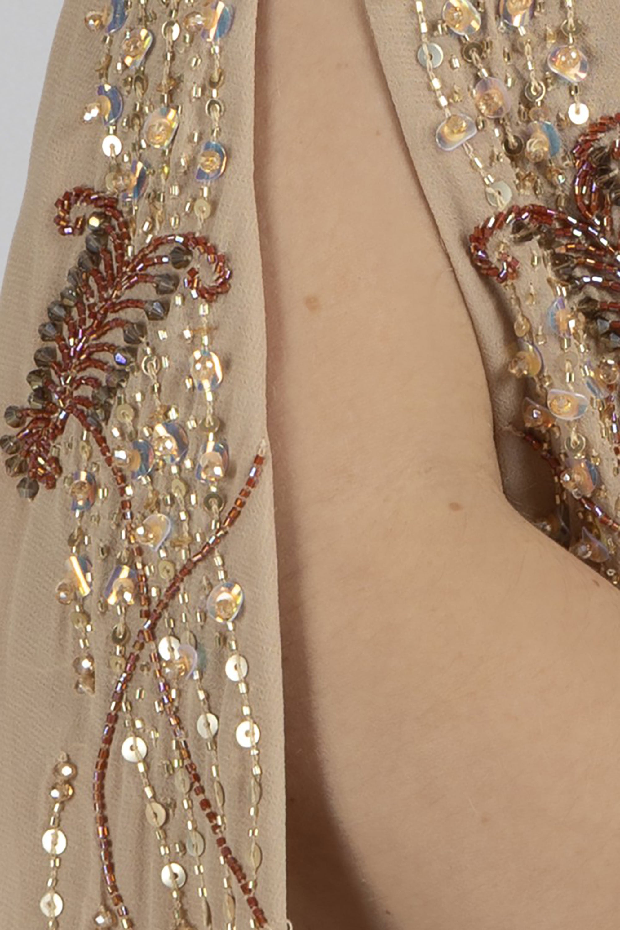 close up of floor-length chiffon caftan with gold and maroon leaf motifs
